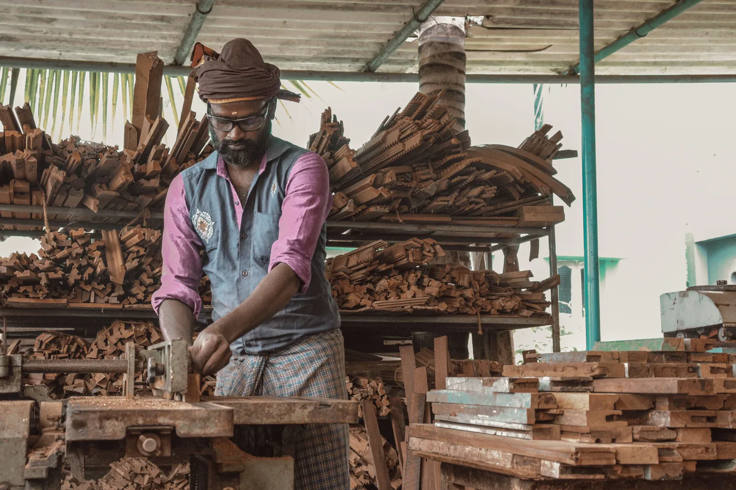 Woodworker shaping a furniture component by hand inside a workshop