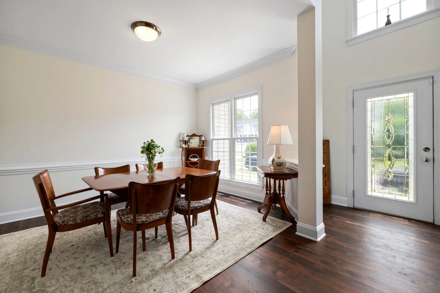 Round solid wood dining table with matching chairs in a warm interior