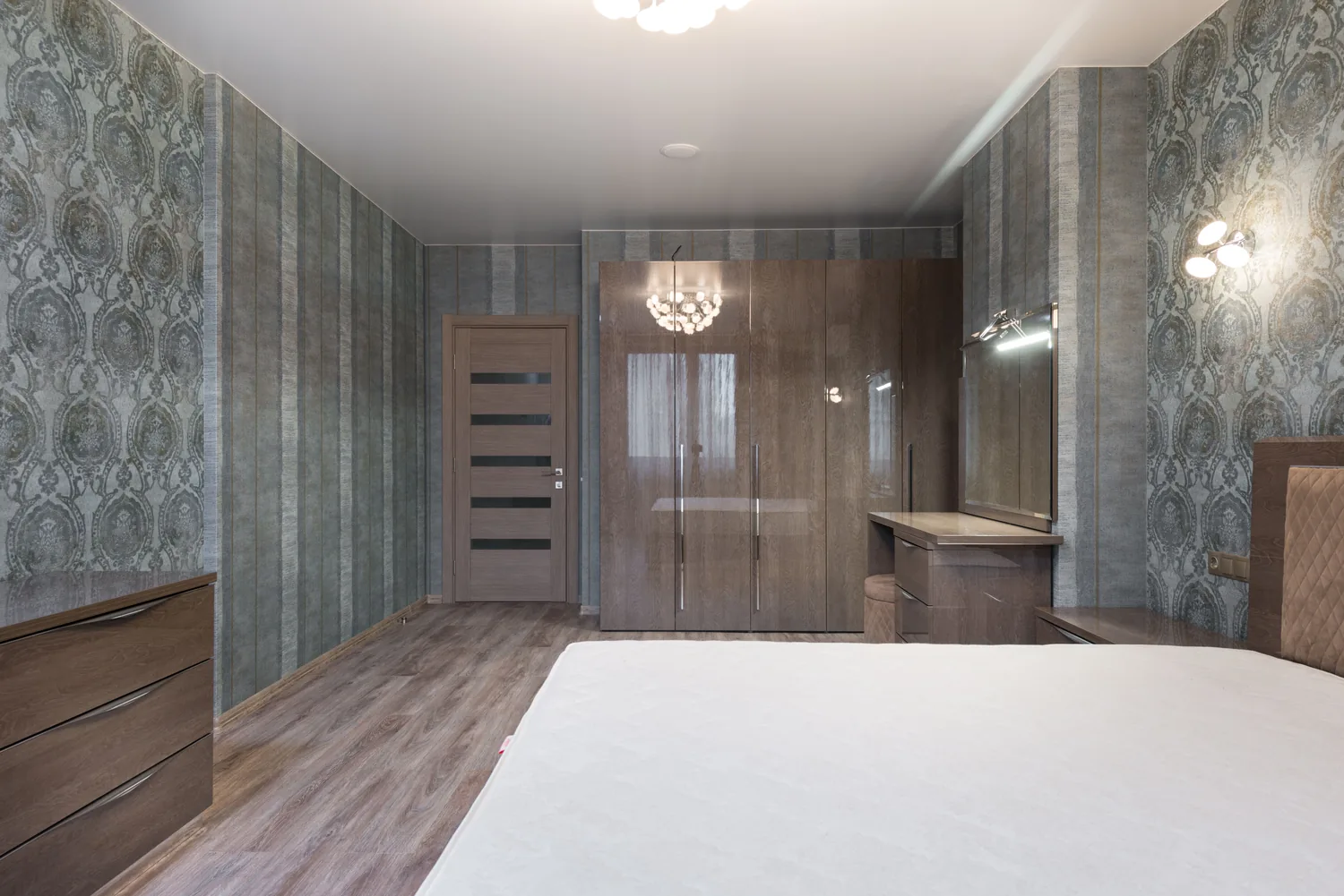 Wide bedroom wardrobe with warm wooden doors and integrated storage